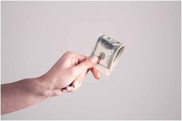 A person’s hand holding cash